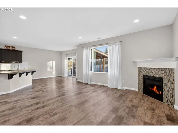 a view of empty room with wooden floor and fireplace