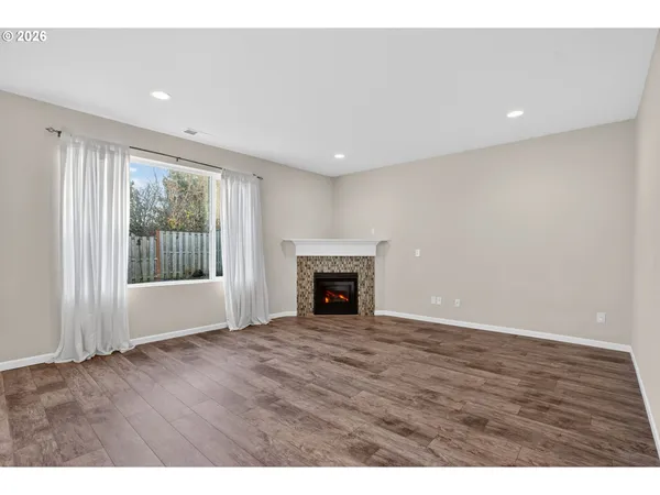 a view of an empty room with a window and fireplace