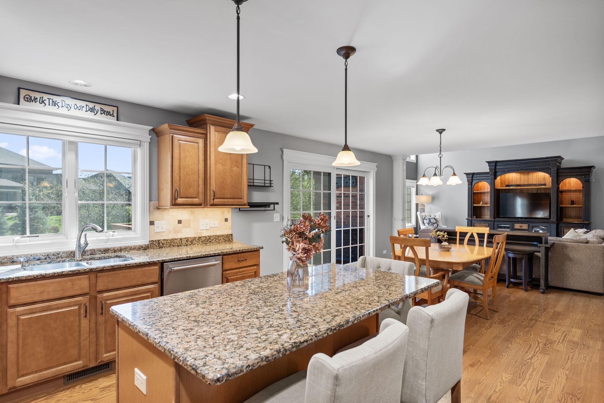 10135 S Branch St. John, IN 46373 - Photo 16 of 45 a kitchen with stainless steel appliances granite countertop a stove top oven a sink dishwasher a dining table and chairs with wooden floor