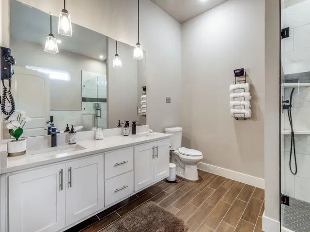 a bathroom with a toilet sink double vanity and mirror