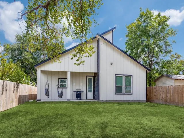 a view of a backyard with plants and large tree
