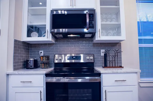 a kitchen with stainless steel appliances a stove and a microwave