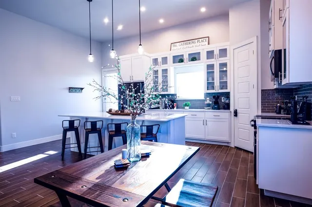 a kitchen with a dining table chairs sink and stove