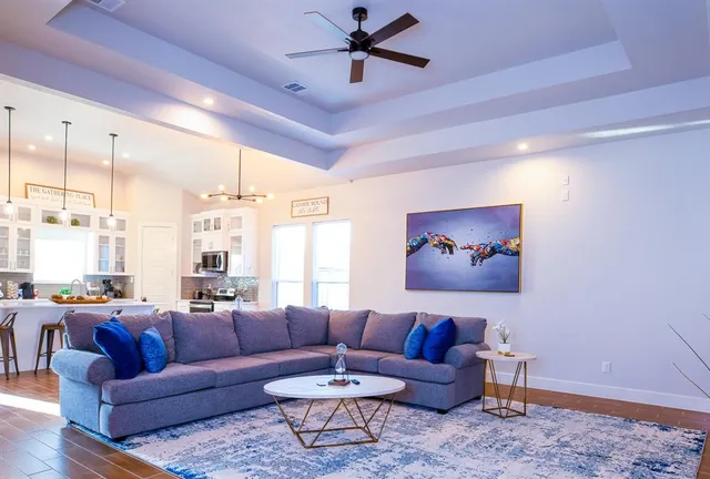 a living room with furniture a ceiling fan and a rug