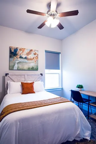 a bedroom with a large bed and a chandelier