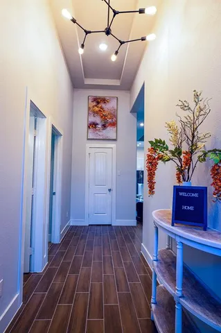 a view of a hallway with wooden floor and furniture