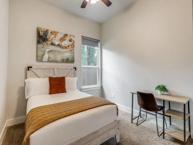 a bedroom with a large bed and a chair