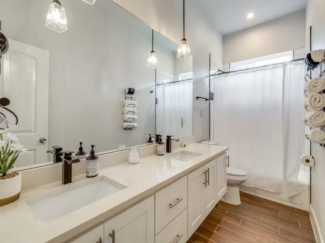 a bathroom with double vanity sink a mirror and a shower