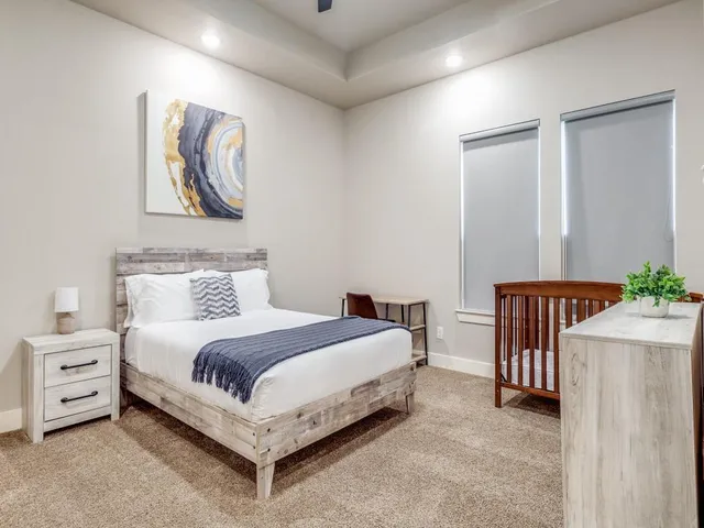 a bedroom with a bed and a painting on the wall