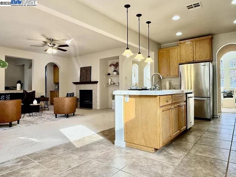 3017 Roslyn Drive Modesto, CA 95355 - Photo 11 of 30 a kitchen with stainless steel appliances granite countertop a sink a stove top oven a refrigerator and a fireplace