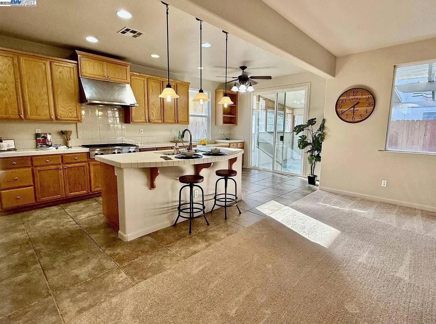 3017 Roslyn Drive Modesto, CA 95355 - Photo 2 of 30 a kitchen with stainless steel appliances granite countertop a stove top oven a sink a dining table and chairs with wooden floor