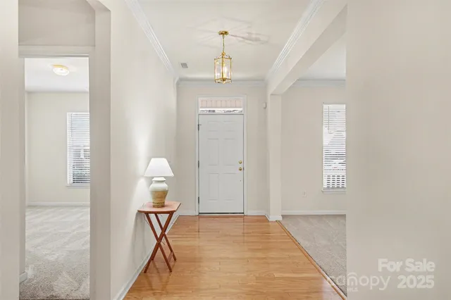a view of a hallway with wooden floor and a bathroom