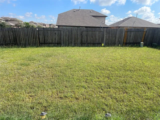 a view of a backyard with wooden fence