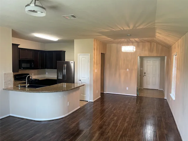 a kitchen with stainless steel appliances granite countertop a sink a stove a refrigerator and cabinets