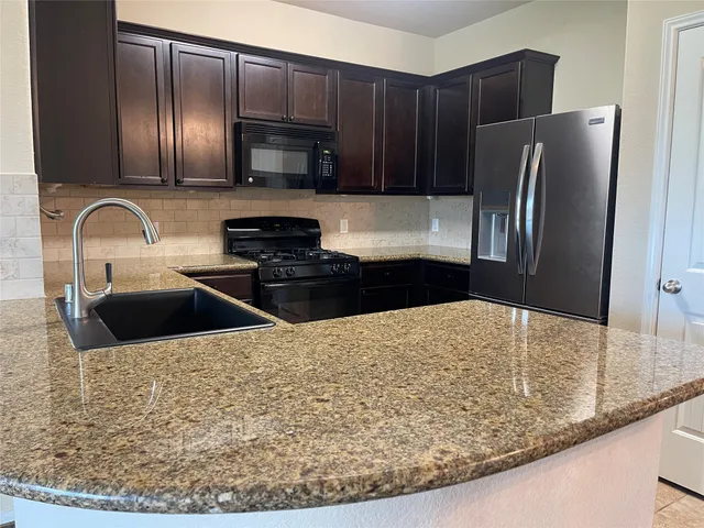 a kitchen with stainless steel appliances wooden cabinets a refrigerator and a sink