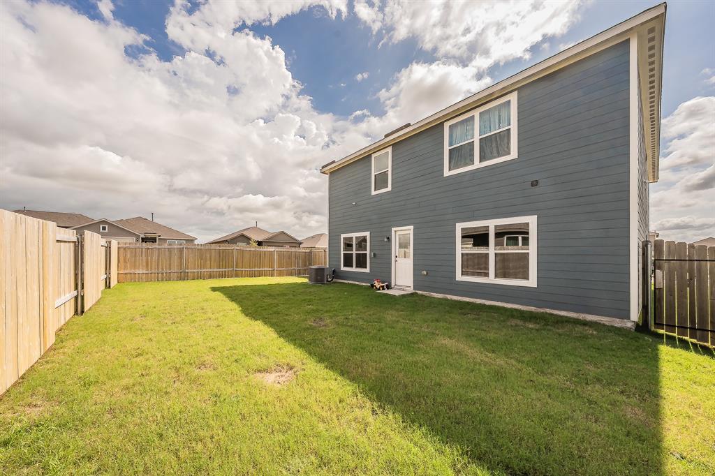 8125 White Sulphur Road Ponder, TX 76259 - Photo 34 of 38 Expansive grassy yard with a full privacy fence and a two-story exterior featuring horizontal siding and white-trimmed windows