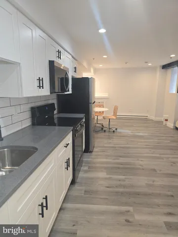 a large kitchen with stainless steel appliances granite countertop a sink and a stove