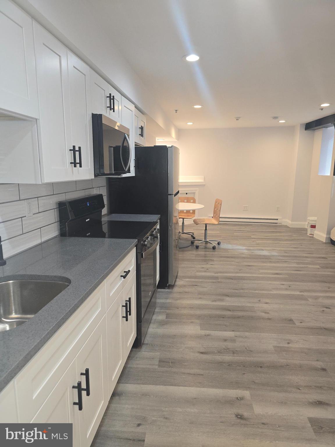 210 Shurs Lane, Unit STUDIO Philadelphia, PA 19128 - Photo 11 of 14 a large kitchen with stainless steel appliances granite countertop a sink and a stove