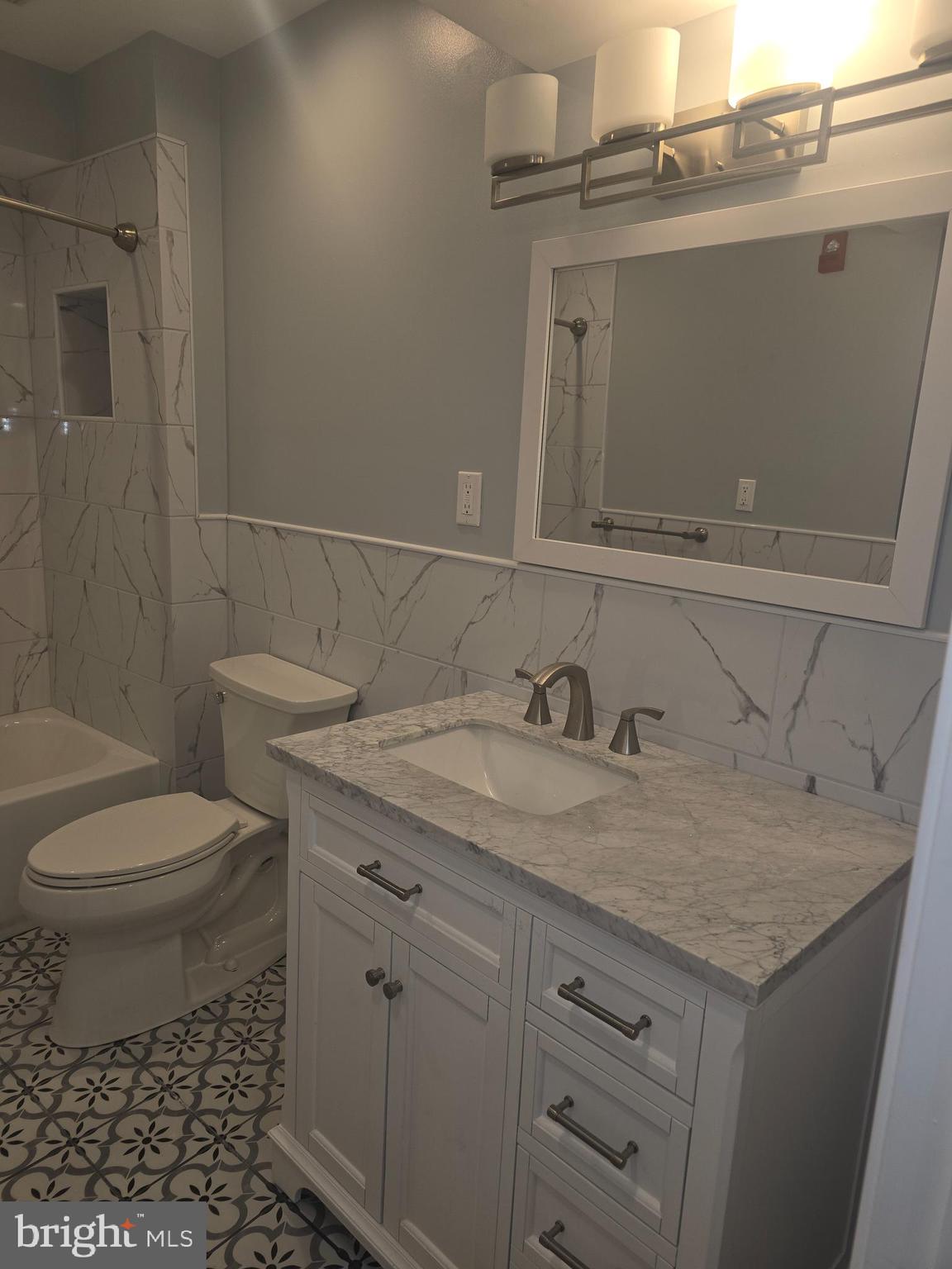 210 Shurs Lane, Unit STUDIO Philadelphia, PA 19128 - Photo 14 of 14 a bathroom with a granite countertop toilet sink and mirror