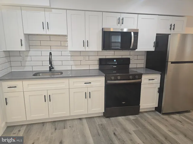 a kitchen with white cabinets and stainless steel appliances