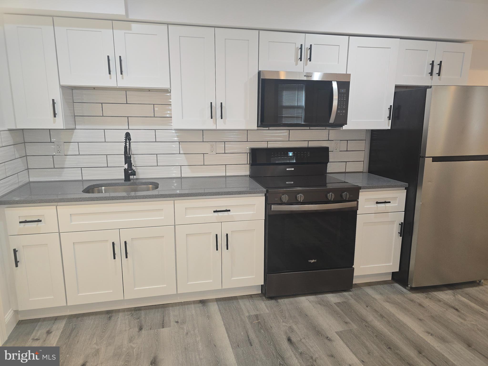 210 Shurs Lane, Unit STUDIO Philadelphia, PA 19128 - Photo 10 of 14 a kitchen with white cabinets and stainless steel appliances