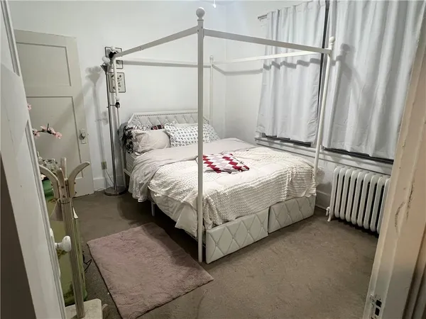 a bedroom with a bed table and a mirror