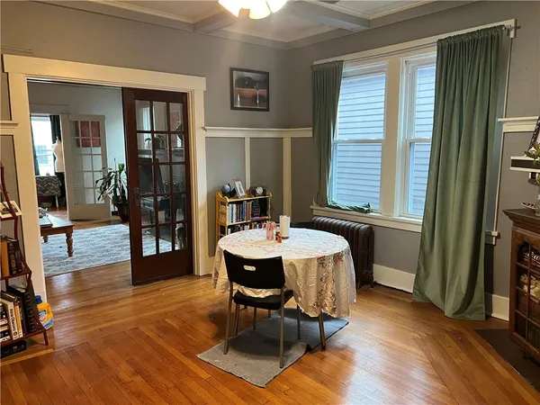 a dining room with wooden floor and a window
