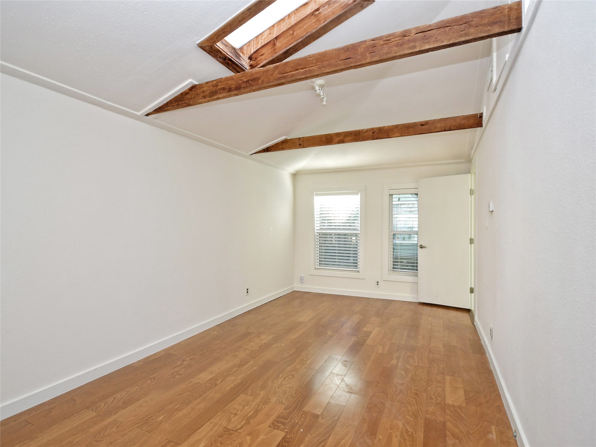 4604 Red River Street, Unit B Austin, TX 78751 - Photo 6 of 15 Exposed wood beams and a skylight create a unique, airy atmosphere in this versatile space.