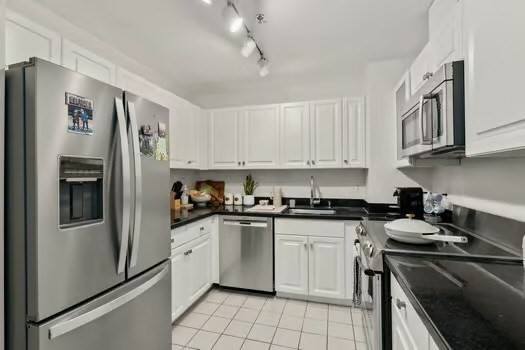 4 Charlesgate East, Unit 604 Boston, MA 02215 - Photo 8 of 20 a kitchen with stainless steel appliances granite countertop white cabinets a refrigerator a sink a stove a dining table and chairs