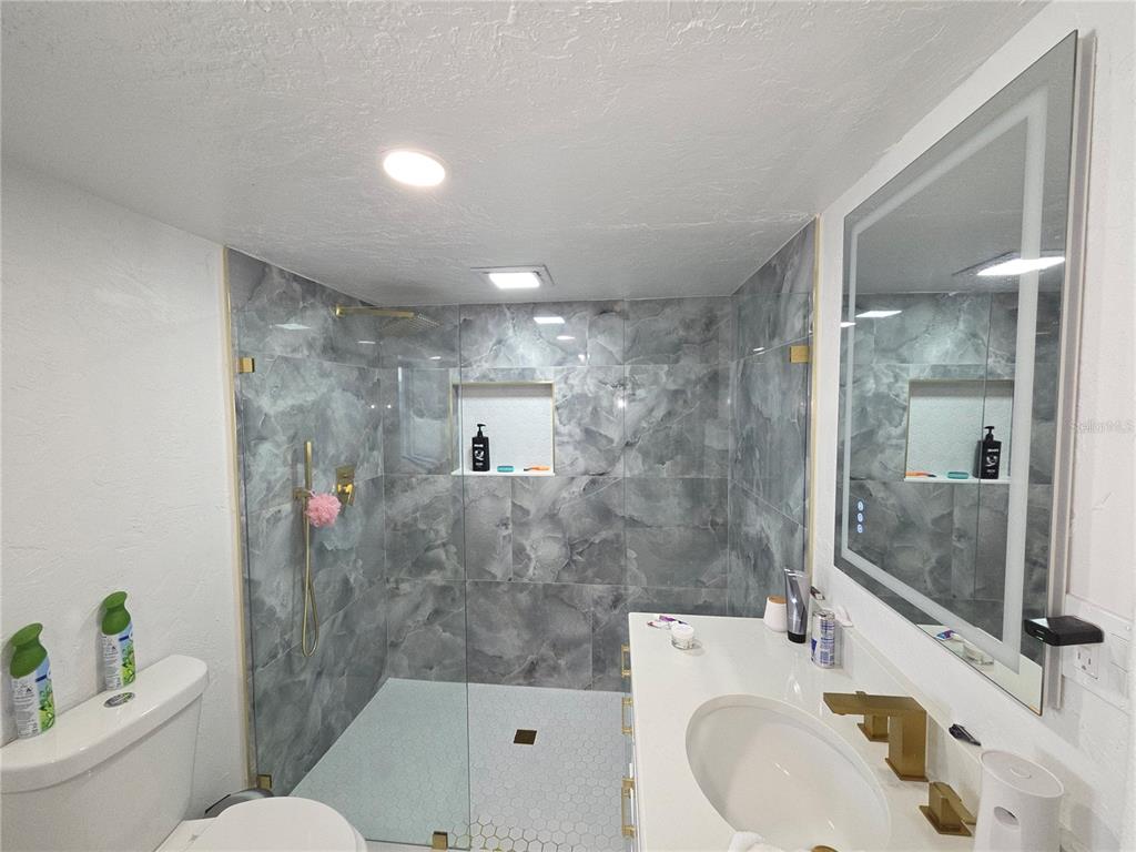 2839 Olympic Street Sarasota, FL 34231 - Photo 23 of 34 a bathroom with a sink mirror toilet and shower