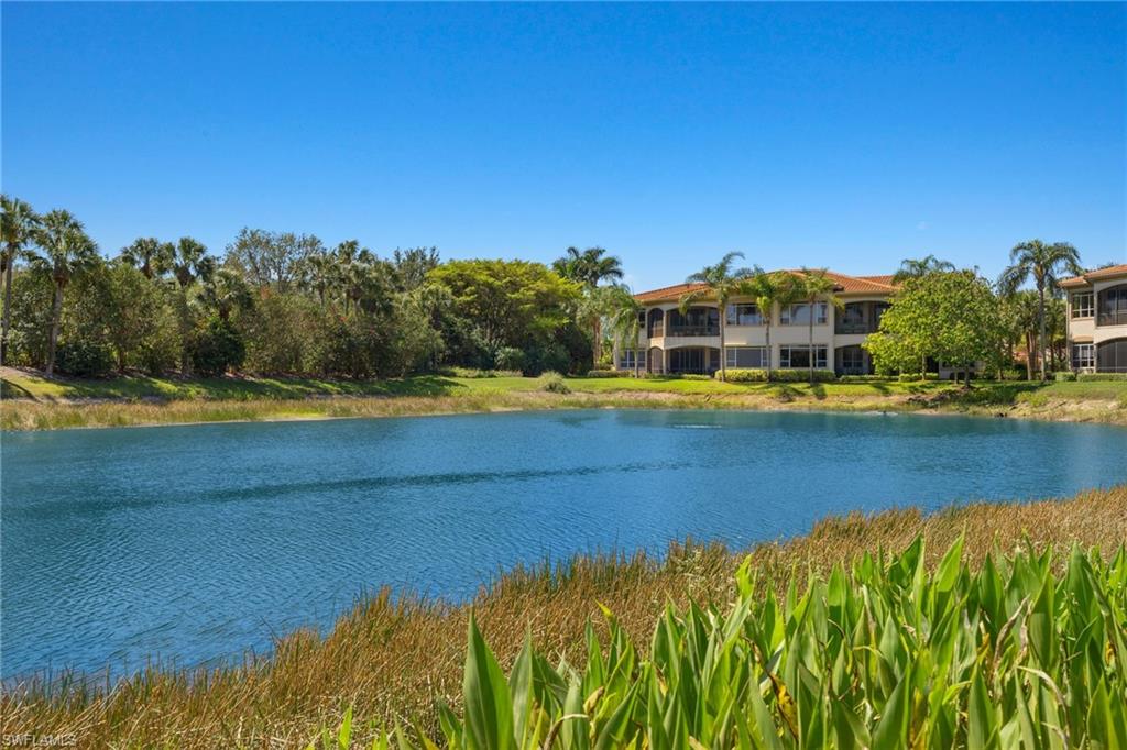 17046 Porta Vecchio Way, Unit 101 Naples, FL 34110 - Photo 22 of 27 a view of a lake with houses in the background