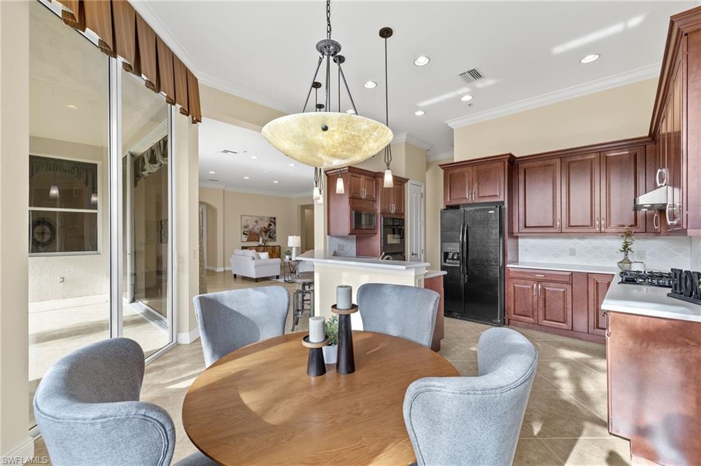 17046 Porta Vecchio Way, Unit 101 Naples, FL 34110 - Photo 5 of 27 a living room with fireplace furniture and a dining table with kitchen view