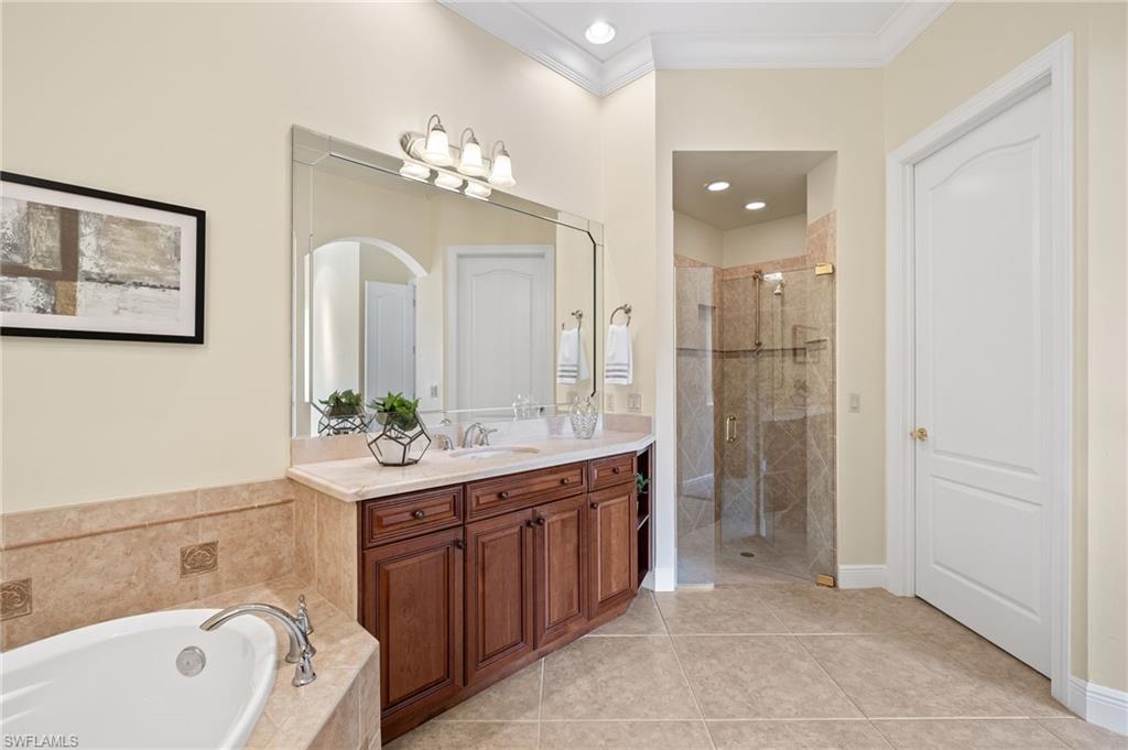 17046 Porta Vecchio Way, Unit 101 Naples, FL 34110 - Photo 9 of 27 a spacious bathroom with a double vanity sink mirror and bathtub