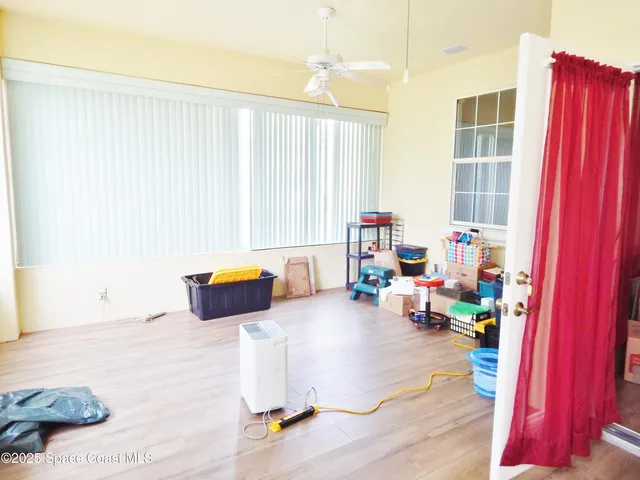 a view of a hallway with wooden floor and furniture