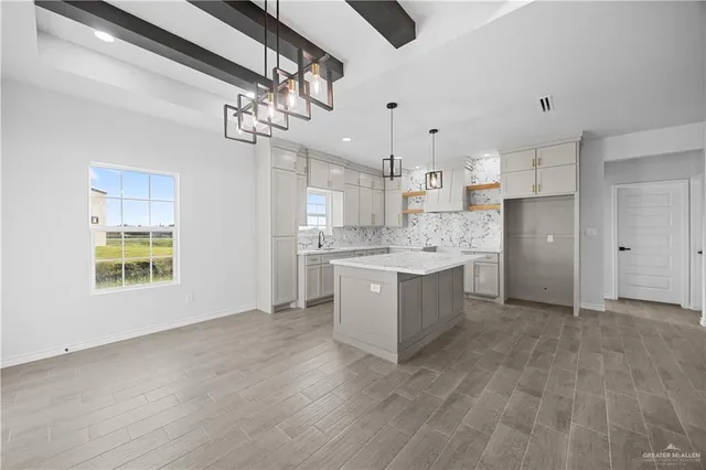 a kitchen with kitchen island white cabinets stainless steel appliances and window