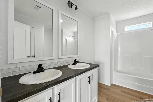 a bathroom with double sink and a mirror