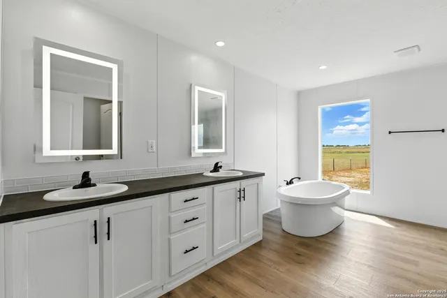 a spacious bathroom with a granite countertop sink a toilet and mirror