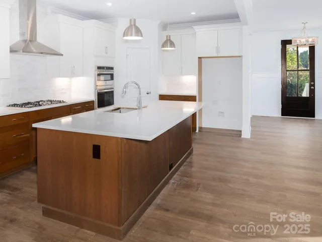 a kitchen with a sink cabinets and wooden floor