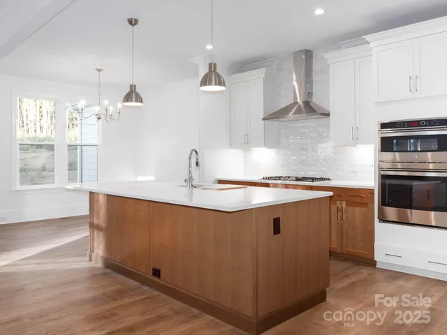 a kitchen with granite countertop white cabinets and stainless steel appliances