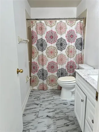 a bathroom with a granite countertop toilet and a shower