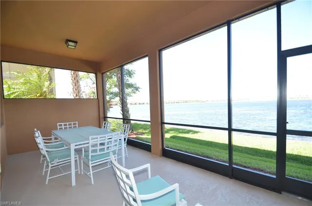 a dining room with furniture and a floor to ceiling window