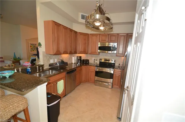 a kitchen with kitchen island granite countertop stainless steel appliances stove microwave and cabinets