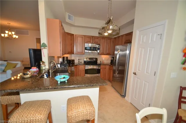 a kitchen with refrigerator and chairs