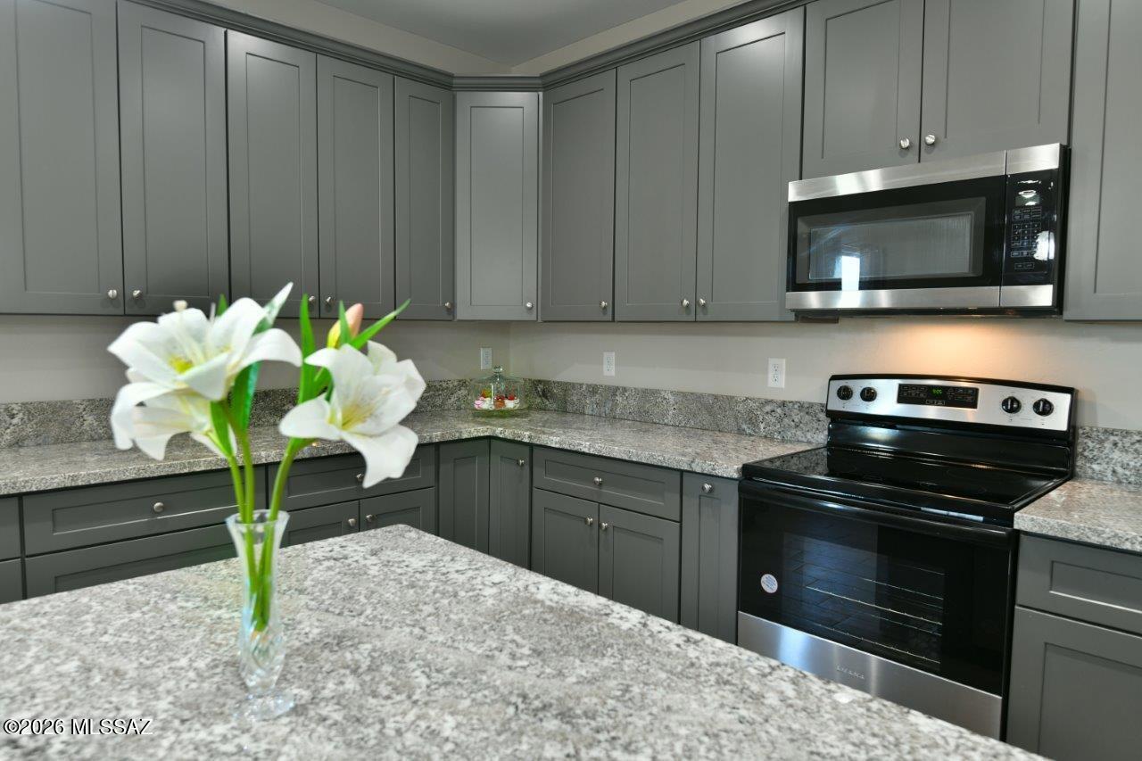 1091 North Vail View Road Vail, AZ 85641 - Photo 5 of 43 a kitchen with a stove a microwave and cabinets