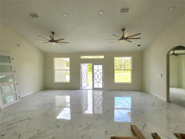 a large kitchen with a wooden floor and large windows