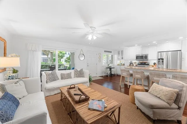 a living room with furniture kitchen view and a large window