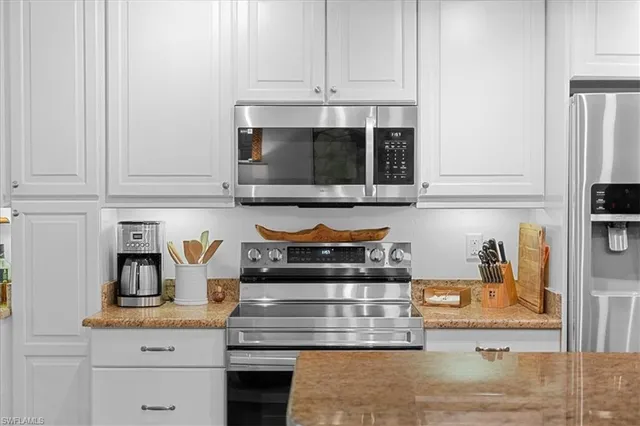 a kitchen with appliances cabinets and a counter top space