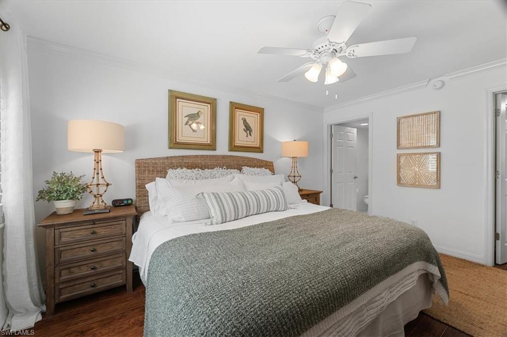 380 4th Avenue South, Unit 380 Naples, FL 34102 - Photo 6 of 19 a bedroom with a large bed and a chandelier