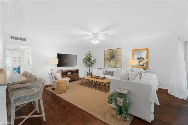 a living room with furniture a large window and a flat screen tv