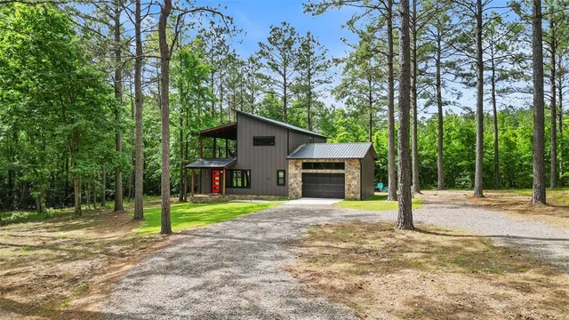 a view of a house with backyard and trees